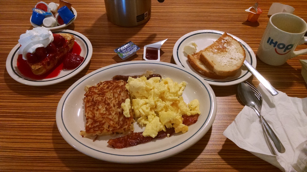 huge beautiful breakfast of stuffed French toast, hash browns, eggs, bacon, sausage, toast, coffee